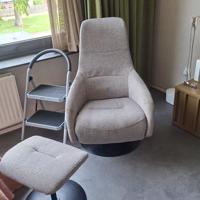Fijne relaxstoel op ronde zwarte schijf hout en stoel kan draaien heeft 2 standen