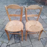 Twee houten stoelen met rieten zitting