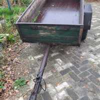 Oude boeren aanhanger met bladveren voorzien van dikke bande