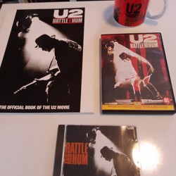 U2 cd, dvd's een tijdschrift en een kopje 
