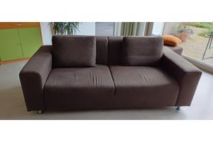 2 chocoladebruine banken en hocker stof