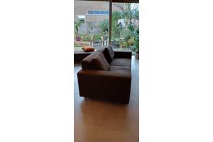 2 chocoladebruine banken en hocker stof