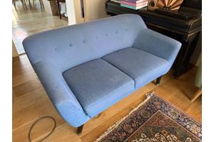 Blauwe tweezitsbank op poten retro