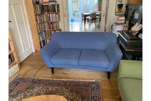 Blauwe tweezitsbank op poten retro