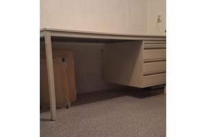 Bureau met een stalen frame en stalen ladekastje.