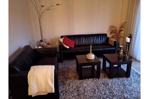 2 zwarte banken, 2 zwarte bijzettafels, grijs hoogpolig tapijt