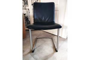 Vier zwart lederen eetkamerstoelen