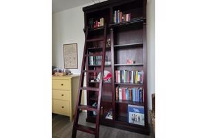 Donkerrode houten bibliotheekkast met trap