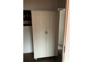 Mooie witte kinder kledingkast op wieltjes.