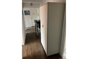 Mooie witte kinder kledingkast op wieltjes.