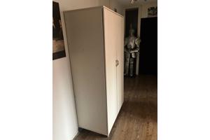 Mooie witte kinder kledingkast op wieltjes.