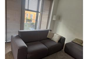 Grijze bank met poef / ottomaan