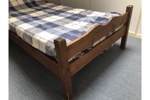 eenpersoons houten bed met matras en dekbed