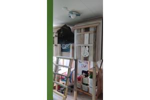 Huisjesbed, bureaus, stoelen en kleed.