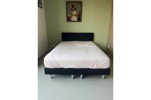 Zwart bed met achterplaat van stof