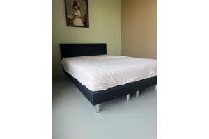 Zwart bed met achterplaat van stof