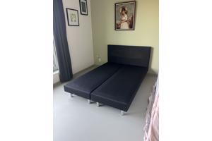 Zwart bed met achterplaat van stof