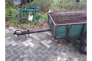Oude boeren aanhanger met bladveren voorzien van dikke bande