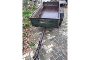 Oude boeren aanhanger met bladveren voorzien van dikke bande