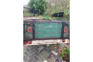 Oude boeren aanhanger met bladveren voorzien van dikke bande