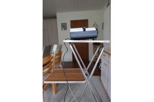 Diaprojector, tafel en projectiescherm