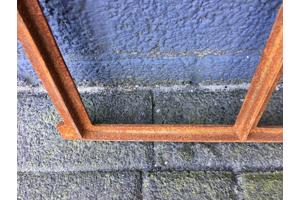 Een klein gietijzeren venster, raam / stalraam