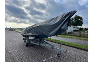 Zeilboot met trailer en buitenboordmotor