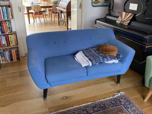 Blauwe tweezitsbank op poten retro