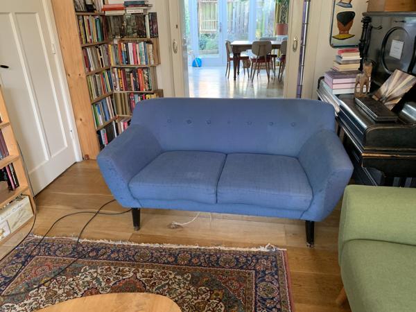 Blauwe tweezitsbank op poten retro