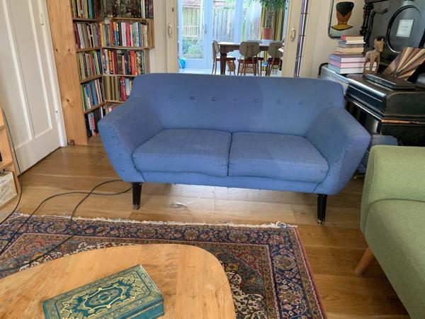 Blauwe tweezitsbank op poten retro