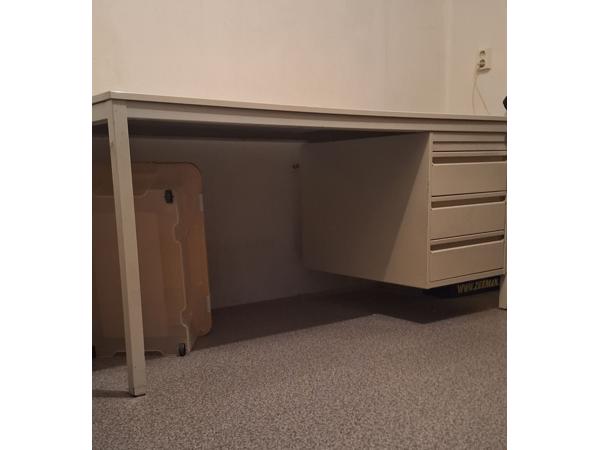 Bureau met een stalen frame en stalen ladekastje.