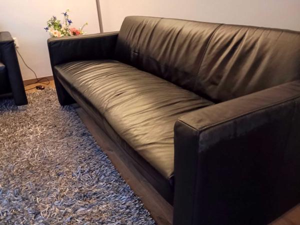 2 zwarte banken, 2 zwarte bijzettafels, grijs hoogpolig tapijt