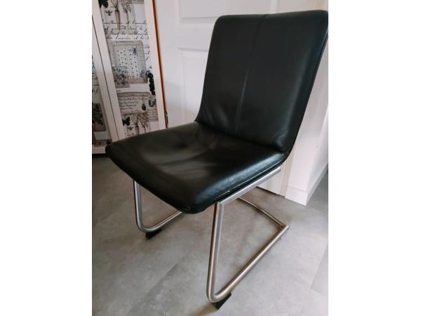 Vier zwart lederen eetkamerstoelen