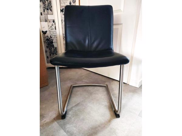 Vier zwart lederen eetkamerstoelen