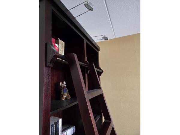 Donkerrode houten bibliotheekkast met trap