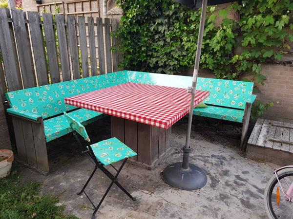 Houten tuinbank en tafel met kleurrijk zeil