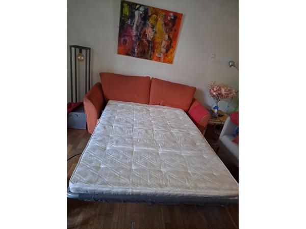 Oranje en rode bedbank. Zit nog lekker bed is makkelijk uitklapbaar