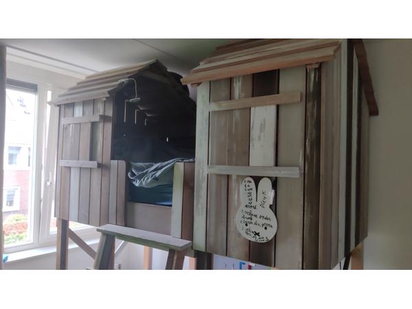 Huisjesbed, bureaus, stoelen en kleed.