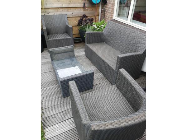 Bank, stoel en tafel voor in de tuin