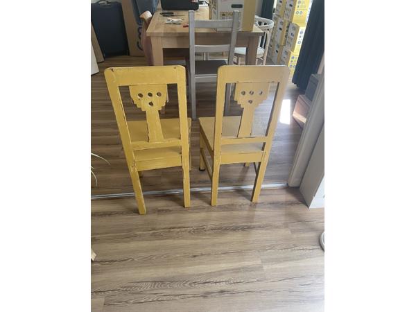 Twee gele houten eetkamer stoelen