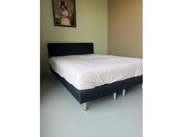 Zwart bed met achterplaat van stof