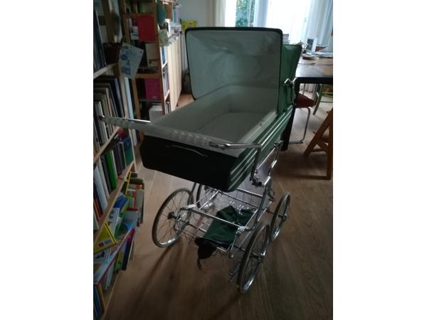 Ouderwetse groene kinderwagen