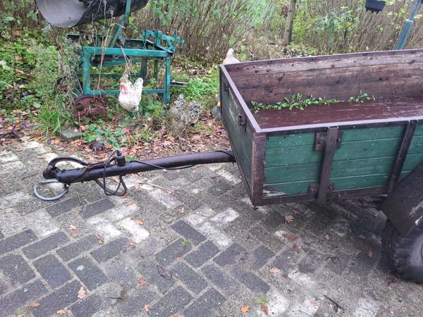 Oude boeren aanhanger met bladveren voorzien van dikke bande