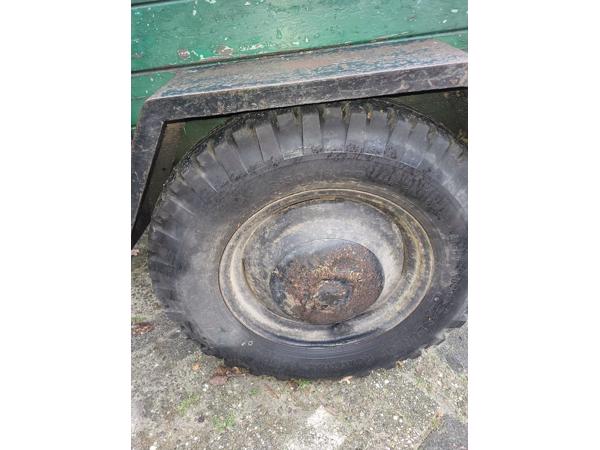 Oude boeren aanhanger met bladveren voorzien van dikke bande