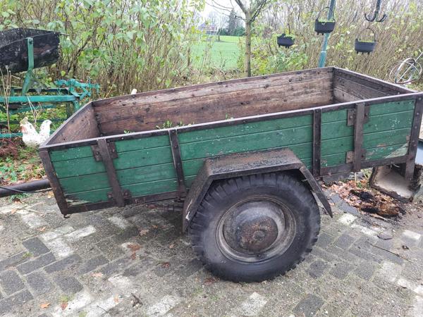 Oude boeren aanhanger met bladveren voorzien van dikke bande