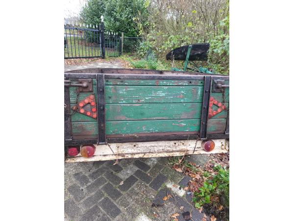 Oude boeren aanhanger met bladveren voorzien van dikke bande