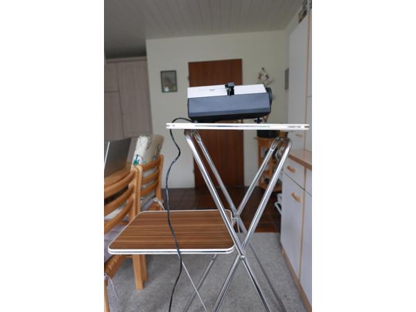 Diaprojector, tafel en projectiescherm