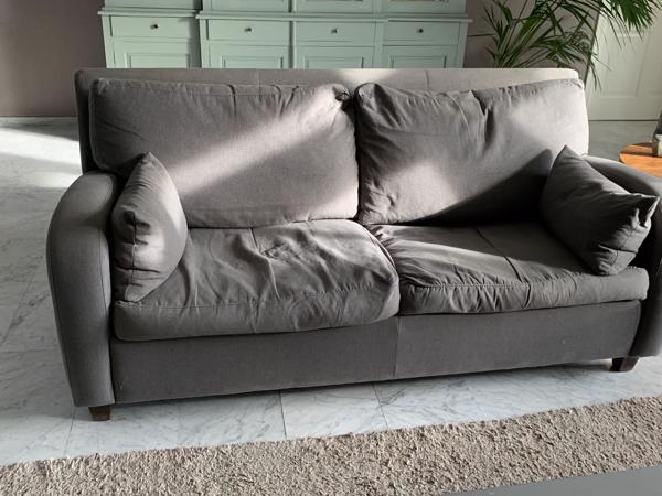 Grijs stoffen twee-zits bankje.